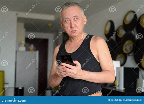 Portrait Of Mature Japanese Man Thinking While Using Phone At Home Stock Image Image Of Adult