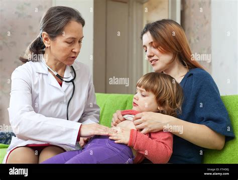 Mature Childrens Doctor Examining Baby In Home Stock Photo Alamy