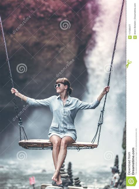 Beautiful Woman Swings Near Waterfall In The Jungle Of Bali Island