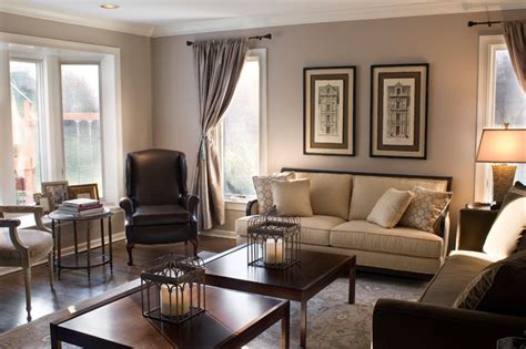 A white fireplace and ceiling beams balance dark walnut floors. Traditional Chocolate Brown and Tan Living Room