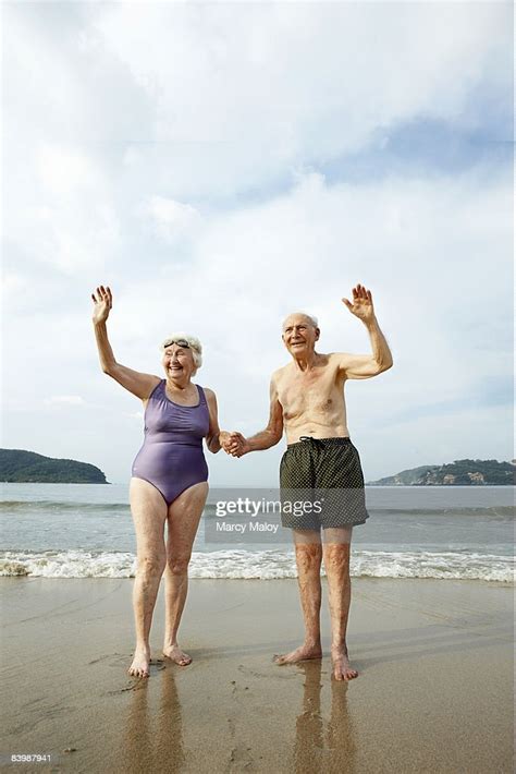 Elderly Couple In Swimsuits Waving On The Beach Photo Getty Images