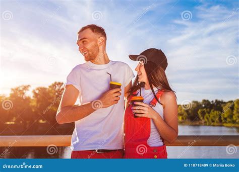 Happy Couple In Love Having Coffee Hugging And Laughing On The Bridge At Sunset Stock Image