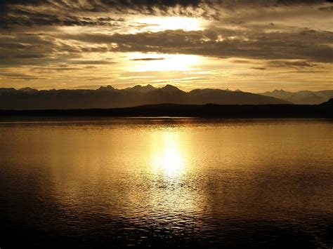 Calm Sea Near Mountain At Sunset · Free Stock Photo