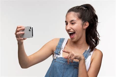 Retrato De Joven Adolescente En Monos Tomando Un Selfie Con Smartphone Foto Gratis
