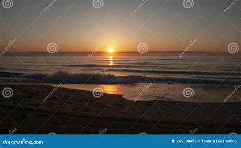 Sunrise Over The Ocean With Gentle Waves Coming Ashore Stock Image
