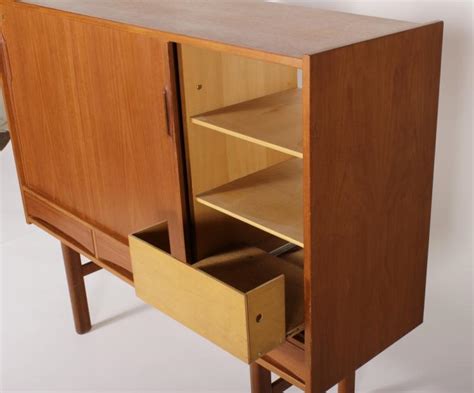 Featuring a director's chair, folding table, and an ottoman with a removable tray, this collection folds completely for convenient storage. Danish Modern Teak Storage Cabinet