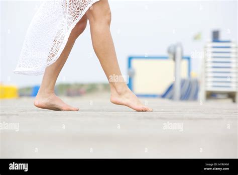 Close Up Low Angle Side View Of A Young Woman Walking Barefoot Outdoors