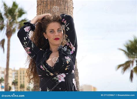Young And Beautiful Woman Blonde With Curly Hair And Blue Eyes Floral Dress And Black Top