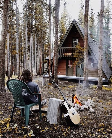 A Person Sitting In A Chair Next To A Fire Pit With A Guitar On It