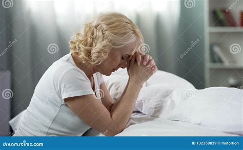 Middle Age Lady Praying Sitting On The Floor Near Bed Faith And Hope