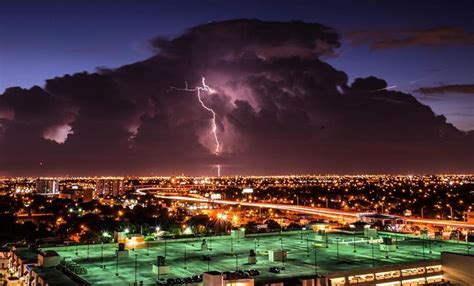 A Lightning Bolt Is Seen Over A City At Night