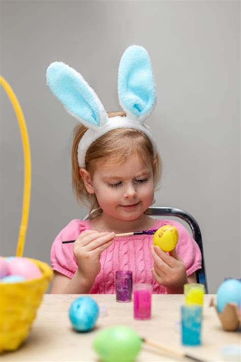 Little Girl In Easter Bunny Ears Painting Colored Eggs Stock Photo