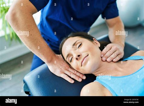 Male Physical Therapist Stretching A Female Patient Neck Stock Photo