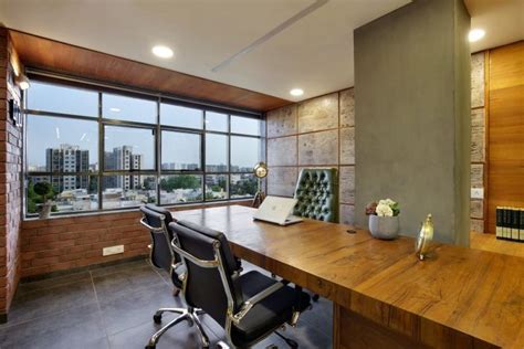 An Office With A Large Wooden Desk And Black Leather Chairs In Front Of