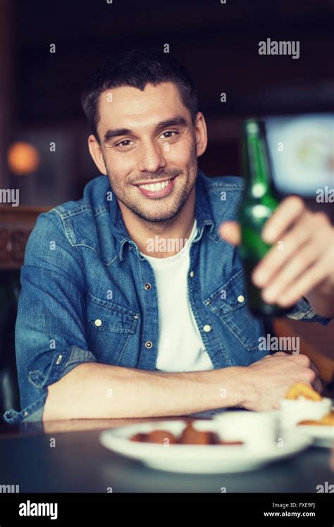 Happy Young Man Drinking Beer At Bar Or Pub Stock Photo Alamy