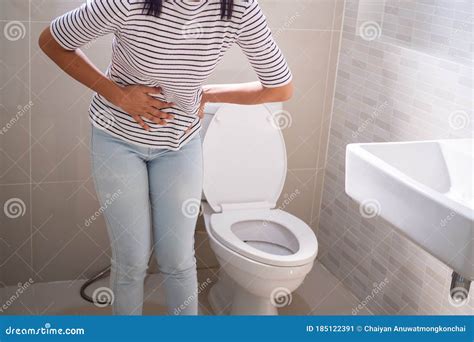 Woman With Diarrhea Standing In The Bathroom Holding Her Stomach