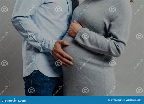 Pregnant Wife Wears Dress Poses Near Husband Who Touches Her Big Belly