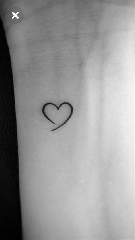 A Small Heart Tattoo On The Wrist Is Shown In Black And White With An Arrow