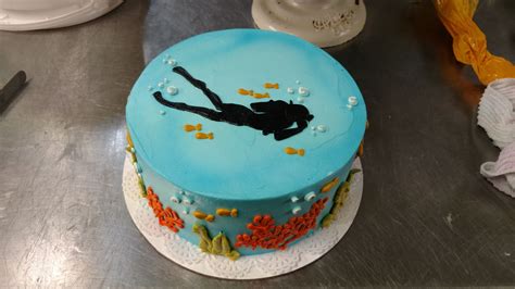 A Scuba Diving Themed Cake With Diver Silhouette And Hand Iced