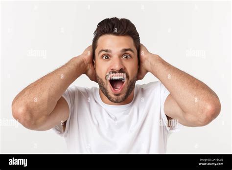 Portrait Of Young Man With Shocked Facial Expression Isolated Over