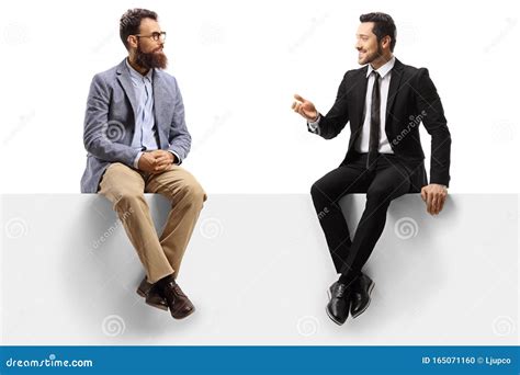 Two Men Sitting On A Panel And Having A Conversation Stock Photo
