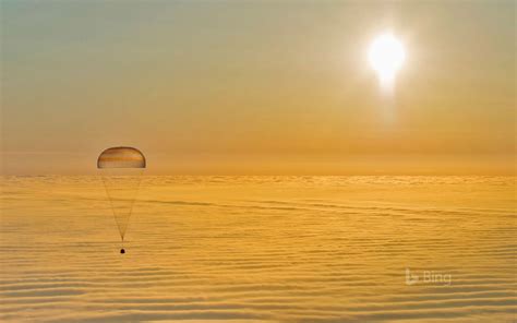 A Parasailer Is Flying Over The Clouds At Sunset