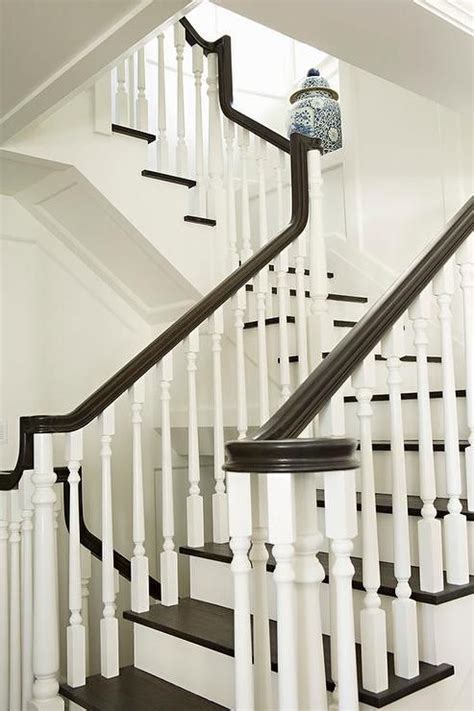 Spiral staircase white stairs with railings. A white staircase with white spindles is contrasted with ...