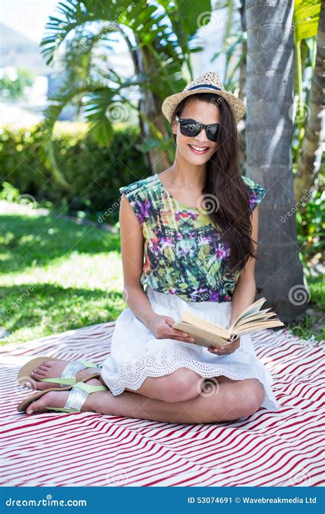 Smiling Beautiful Brunette Sitting And Reading A Book Stock Image