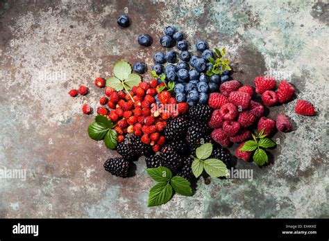 Assorted Fresh Berries With Leaves On Metal Background Stock Photo Alamy