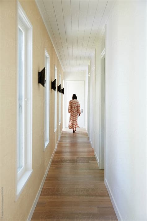 Woman Walking Down Hallway Of Modern Design Home By Stocksy Contributor Trinette Reed Stocksy