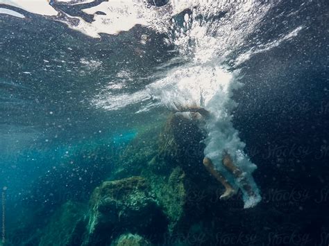 Underwater View Of A Person Falling Down Into The Water By Stocksy