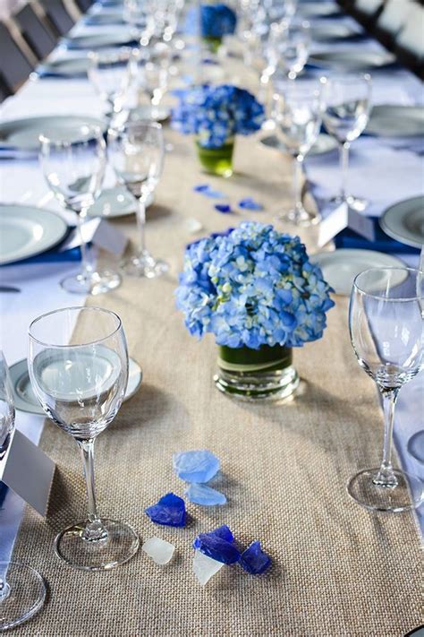 Small And Low Hydrangea Centerpieces On Top Of A Burlap Linen Runner At