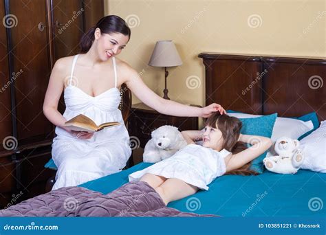 Adult Mother Teaches Her Daughter To Read Touching Her Head Stock