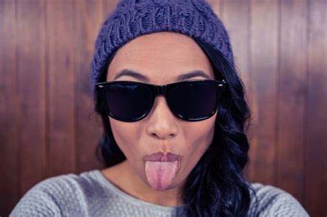 Premium Photo Asian Woman Sticking Out Her Tongue Against Wooden Wall