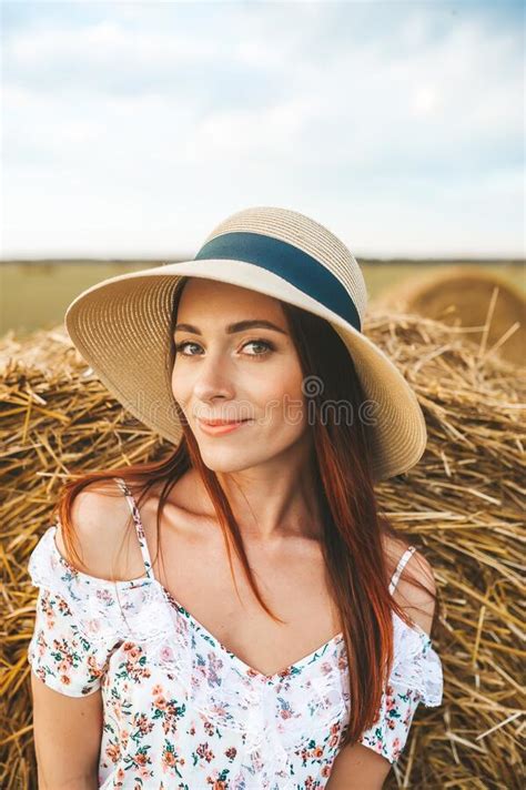 Beautiful Girl In Hat Near A Hay Bale In The Countryside Stock Image