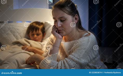 Young Sad Woman Worried About Her Little Sick Son Sleeping In Bed Concept Of Lonely Mother