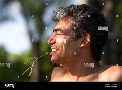 30s Hispanic Man Eating Grass And Smiling In Park Buenos Aires