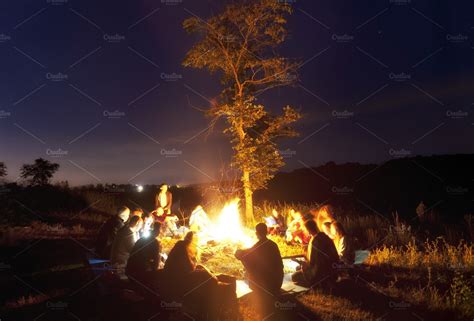 People Sitting Around The Bonfire High Quality Stock Photos