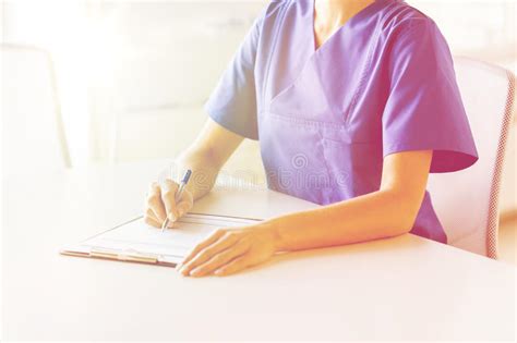 Close Up Of Doctor Or Nurse Writing To Clipboard Stock Photo Image Of