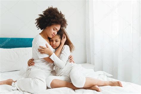 Madre Consolando A Su Hija Sentada En El Dormitorio Abrazándose 2023