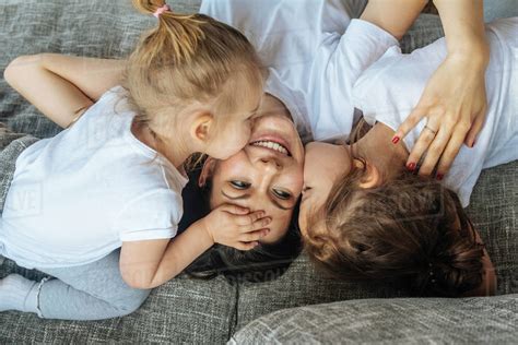 Babes Kissing Their Mother S Cheek Stock Photo Dissolve