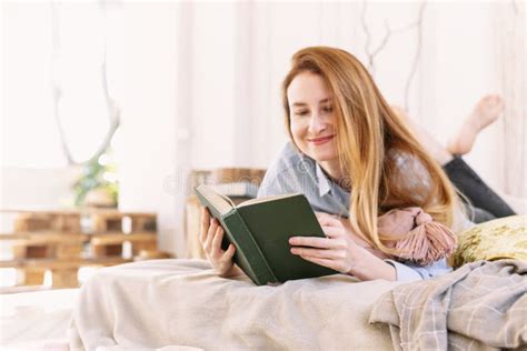 Lovely Woman Reading A Book Lying In Bed A Young Adult Girl Is