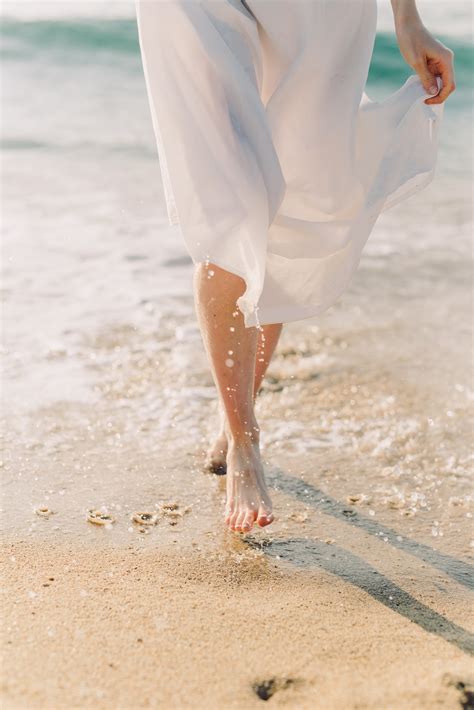 Woman In White Dress Walking On Beach · Free Stock Photo