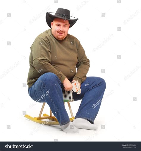 Overweight Cowboy Riding On A Rocking Horse Stock Photo 207686626