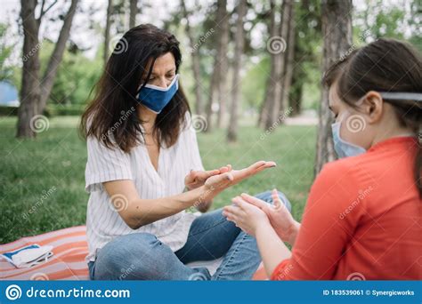 Woman And Daughter Spreading Hand Sanitizer On Their Hands Stock Image Image Of Pandemic Park