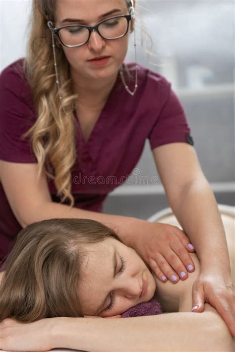 Beautiful Young Girl With Massage At The Spa Center Female Therapist Massaging Shoulders During