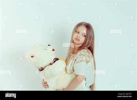 Close Up Portrait Of A Cute Annoyed Sad Bored Girl Holding Teddy Bear