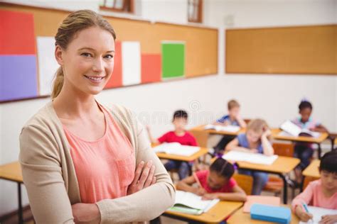 Pretty Teacher Smiling At Camera At Top Of Classroom Stock Image