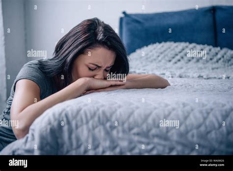 Beautiful Depressed Woman Crying And Lying On Bed At Home Stock Photo
