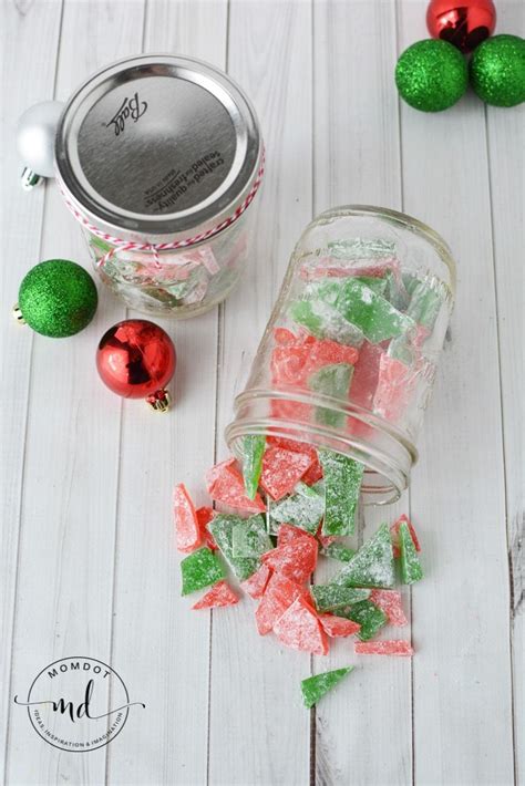 Green And Red Candies In A Jar Next To Christmas Ornaments On A White